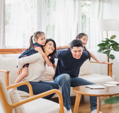 Happy Asian family playing together at sofa, home living room